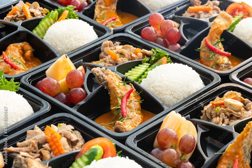 Thai food lunch boxes in plastic packages. Rice salmon with red curry.