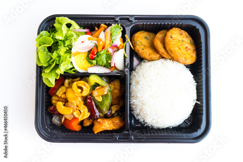 Thai food lunch boxes in plastic packages, Stir fried Chicken with cashew nuts, Fish cake and Spicy Egg Salad.