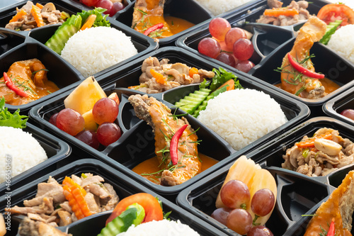 Thai food lunch boxes in plastic packages. Rice salmon with red curry.