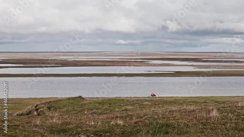 Russian tundra in Summer. Transpolar reservoir on Yamal Peninsula. Unrecognizable fishermen get ready for fishing. photo