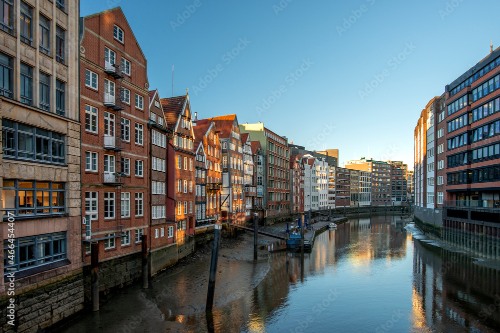 The Nikolaifleet with old buildings next to the canal  in Hamburg on a cloudless day in the afternoon