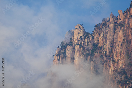 A dynamic view of white clouds surrounding a granite mountain. Landscape of Mount Huangshan (Yellow Mountain). UNESCO World Heritage Site. Anhui Province, China.