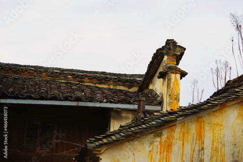 Old house with gray tile roof. White walls with yellow-brown stripes. Jujing Village is a typical small round village surrounded by mountains and water. Wuyuan, Jiangxi, China. photo