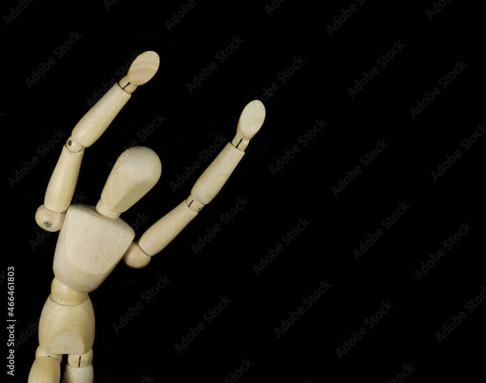 Wooden mannequin isolated on black background, copy space for text Wooden mannequin isolated on black background, copy space for text