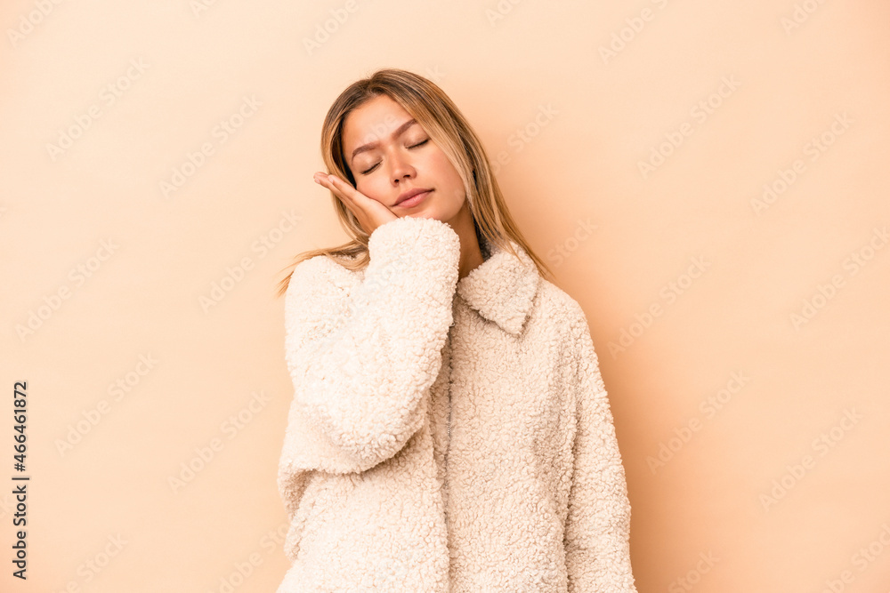 Young caucasian woman isolated on beige background who is bored, fatigued and need a relax day.