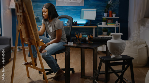 Black artistic person designing masterpiece of vase on table in artwork space. African american young woman creating modern drawing for professional fine art project. Adult with creativity