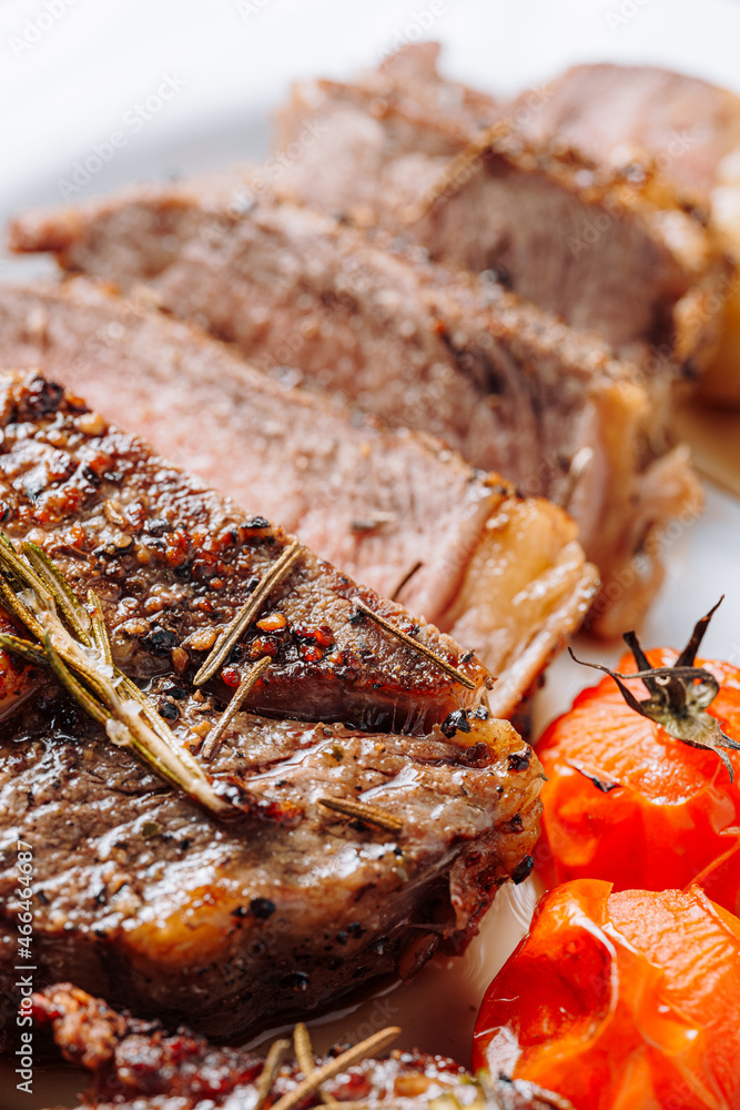 Ταπετσαρία juicy, well-done ribeye steaks on a white platter on a dark wooden table top wit