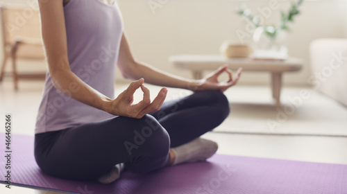 Closeup of young woman meditating and practicing yoga at home. Recreation, self care, yoga training, fitness, breathing exercises, meditation, relaxation, healthy lifestyle concept