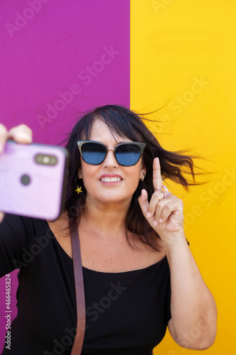 woman  making selfie on smartphone over colored background