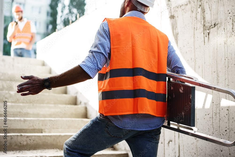 Professional builder carrying metal ladder, close up Professional builder carrying metal ladder, close up