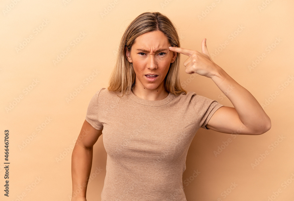 Young caucasian woman isolated on beige background showing a disappointment gesture with forefinger. Young caucasian woman isolated on beige background showing a disappointment gesture with forefinger.