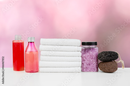 Various spa beauty threatment products and towels against blurred background photo