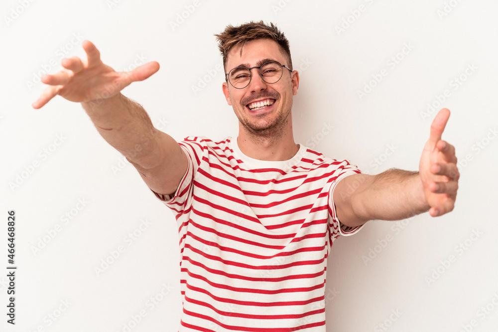 Young caucasian man isolated on white background feels confident giving a hug to the camera. Young caucasian man isolated on white background feels confident giving a hug to the camera.