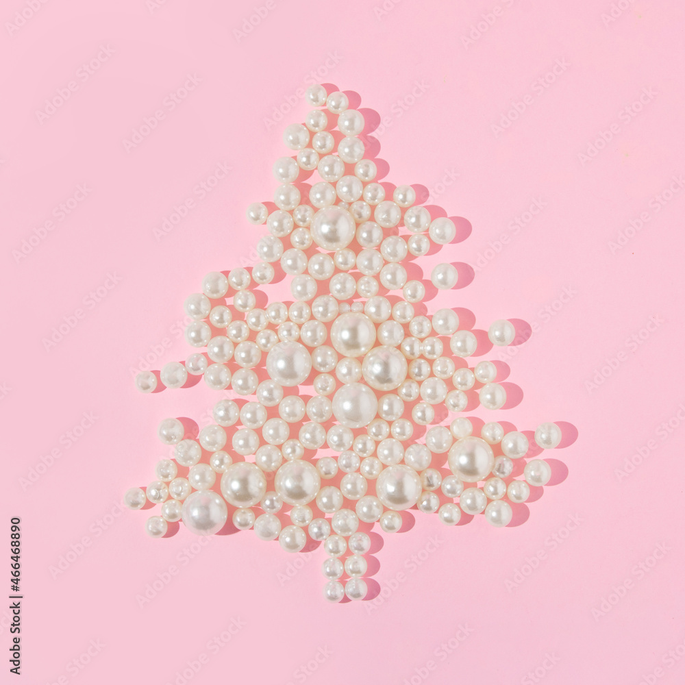 Creative layout with white pearls forming Christmas tree on pastel pink background. Retro fashion aesthetic idea. Minimal New Year or Christmas celebration concept.