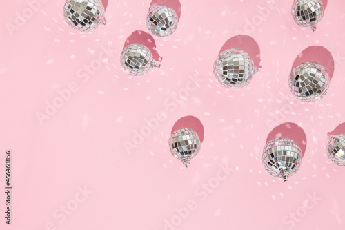 Christmas and New Year creative layout with disco ball decoration on pastel pink background. 80s or 90s aesthetic fashion holiday concept. Trendy minimal holiday idea.