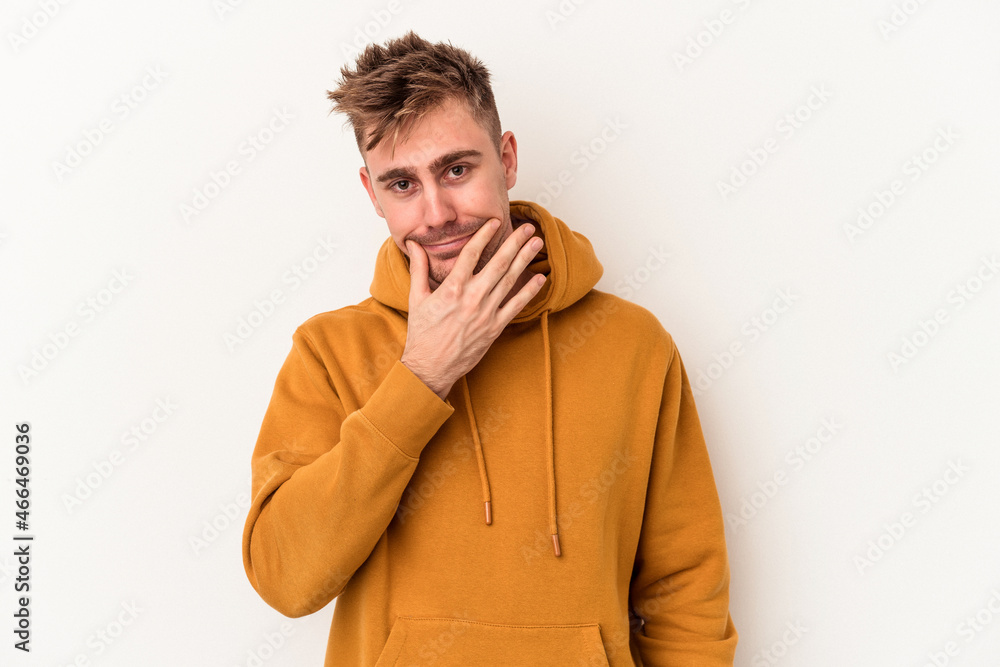 Young caucasian man isolated on white background doubting between two options. Young caucasian man isolated on white background doubting between two options.