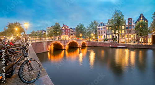 Romantic Evening in Amsterdam. Panoramic views of the famous old houses, bicycles, bridge and canal in the old center. Amsterdam, Holland, Netherlands, Europe