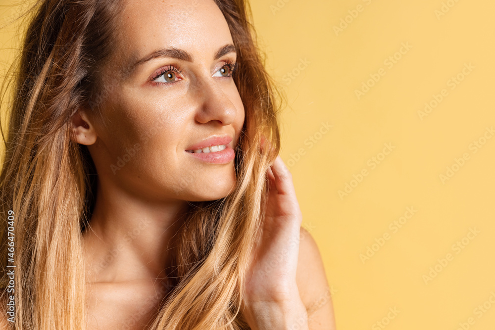 Close-up portrait of young beautiful smiling woman without makeup isolated over yellow studio background. Natural beauty concept. Close-up portrait of young beautiful smiling woman without makeup isolated over yellow studio background. Natural beauty concept.