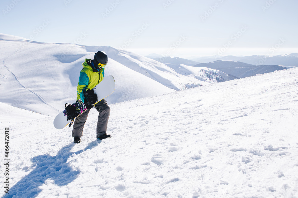 man snowboarder at the top of the mountains