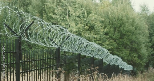 Long fence with barbed wire. The concept of closing borders, districts and specially protected objects
