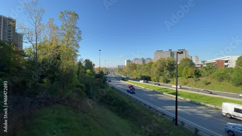 Traffic driving fast on Don Valley Parkway with cars, trucks, motorcycles during Fall morning commute; wide 4K photo