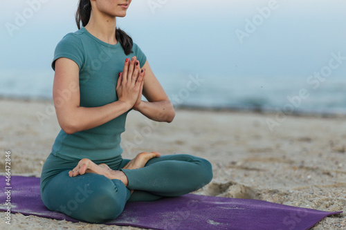 woman sitting on the beach in lotus pose and meditate