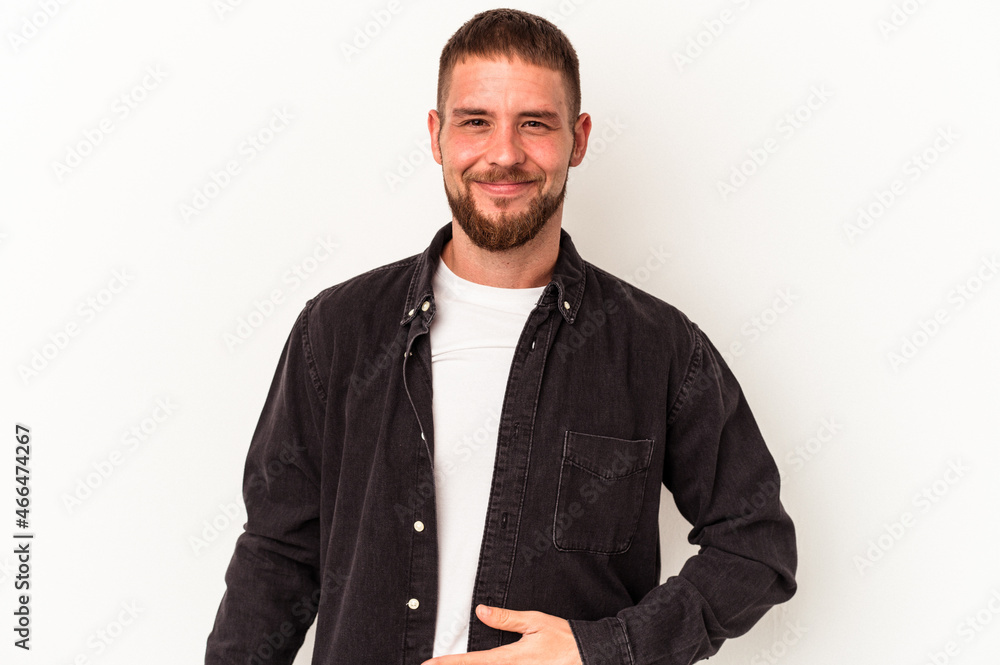Young caucasian man with diastema isolated on white background touches tummy, smiles gently, eating and satisfaction concept. Young caucasian man with diastema isolated on white background touches tummy, smiles gently, eating and satisfaction concept.