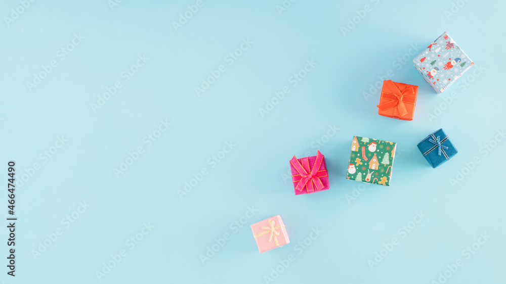 Christmas arrangement made of colorful gifts on a pastel blue background with copy space. Minimal New Year concept. December or winter inspiration. Christmas arrangement made of colorful gifts on a pastel blue background with copy space. Minimal New Year concept. December or winter inspiration.