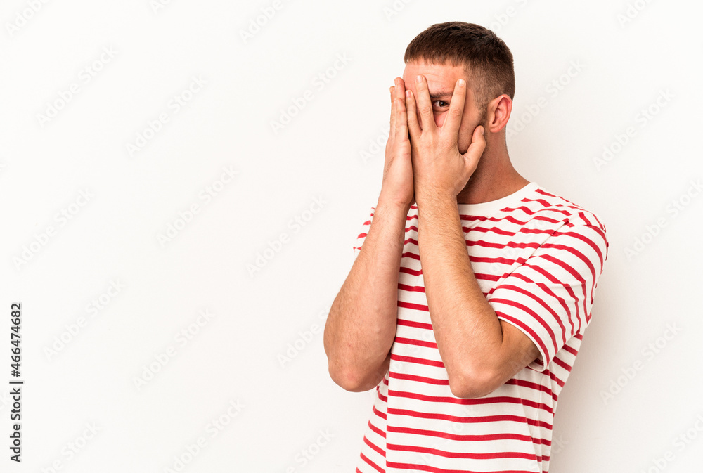 Young caucasian man with diastema isolated on white background blink through fingers frightened and nervous. Young caucasian man with diastema isolated on white background blink through fingers frightened and nervous.