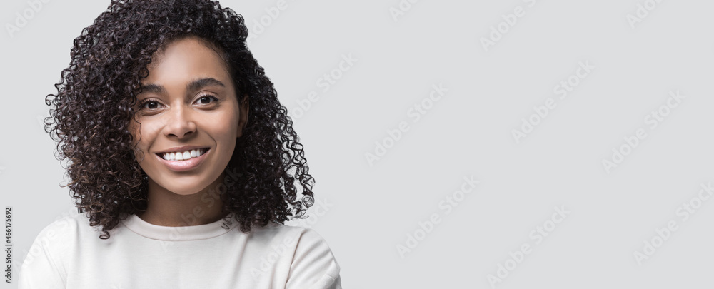 Leinwandbild Motiv - kite_rin : Mixed race young woman isolated studio portrait. Smiling cute african american student girl closeup studio shot. Panoramic banner.