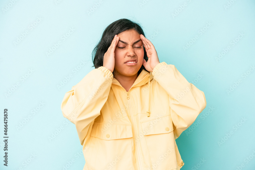 Young latin woman isolated on blue background touching temples and having headache. Young latin woman isolated on blue background touching temples and having headache.