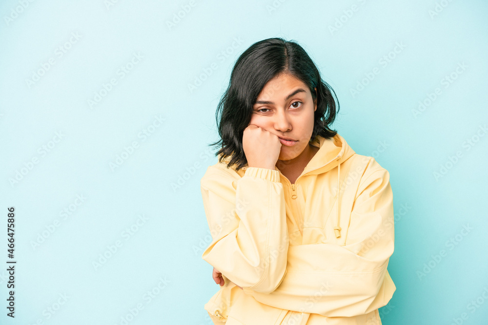 Young latin woman isolated on blue background who feels sad and pensive, looking at copy space. Young latin woman isolated on blue background who feels sad and pensive, looking at copy space.
