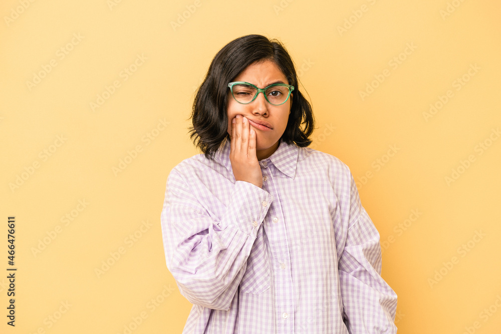 Young latin woman isolated on yellow background having a strong teeth pain, molar ache. Young latin woman isolated on yellow background having a strong teeth pain, molar ache.
