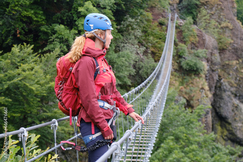 Woman with via ferrata gear on a steel wire bridge at Skalka, Kremnica, Slovakia. Climber, active, adventure, tourism. photo