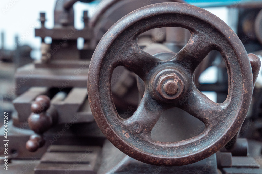 Close-up and selective focus to the circular lever of an old industrial lathe. Close-up and selective focus to the circular lever of an old industrial lathe.