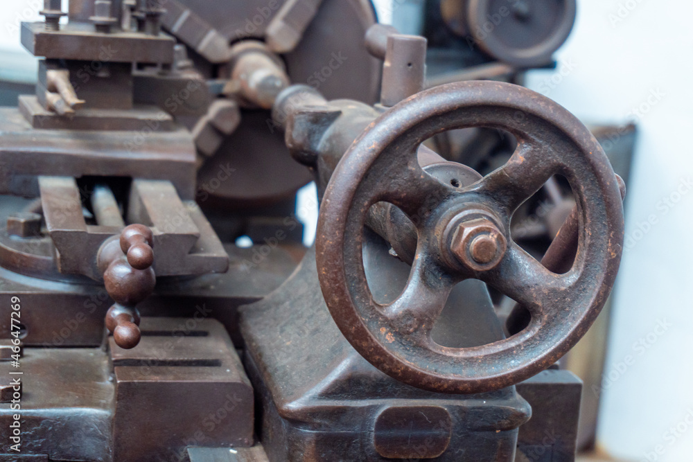 Close-up and selective focus to the circular lever of an old industrial lathe.