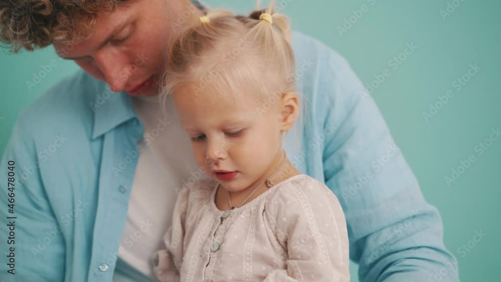 Confident father talking with daughter in blue studio Confident father talking with daughter in blue studio