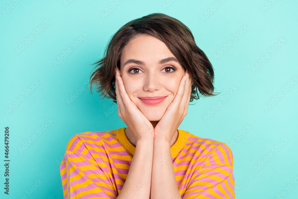 Portrait of attractive calm cheery brown-haired girl touching face isolated over bright teal turquoise color background Portrait of attractive calm cheery brown-haired girl touching face isolated over bright teal turquoise color background