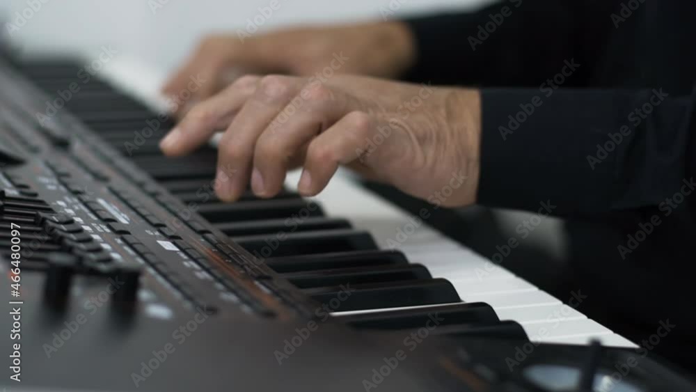 Hands of a man pressing the keys of a musical instrument piano. The musician plays the melody. Electric keyboard musical instrument. Hands of a man pressing the keys of a musical instrument piano. The musician plays the melody. Electric keyboard musical instrument.