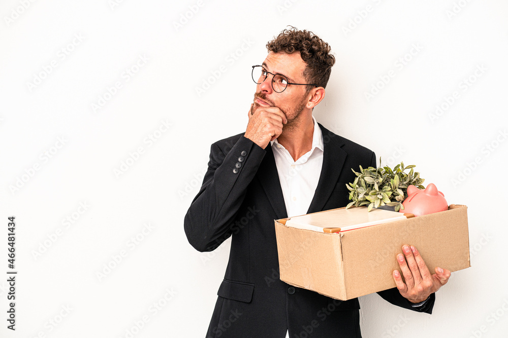 Young caucasian business man fired from his job isolated on white background looking sideways with doubtful and skeptical expression. Young caucasian business man fired from his job isolated on white background looking sideways with doubtful and skeptical expression.