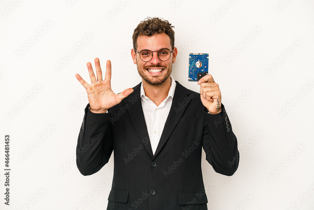 Young caucasian computerized holding HDD isolated on white background smiling cheerful showing number five with fingers. Young caucasian computerized holding HDD isolated on white background smiling cheerful showing number five with fingers.