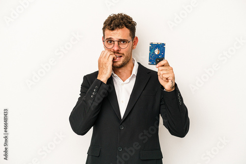 Young caucasian computerized holding HDD isolated on white background biting fingernails, nervous and very anxious.