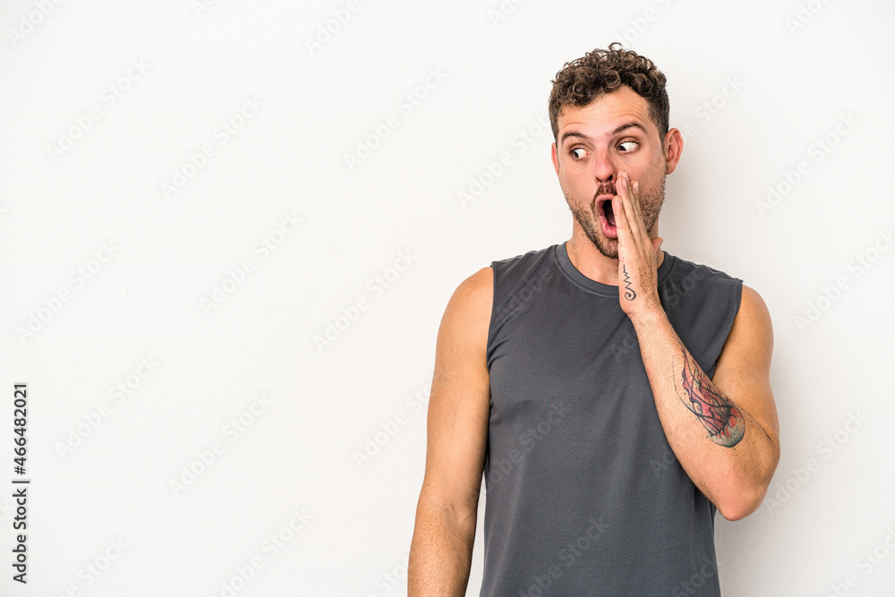 Young caucasian man isolated on white background is saying a secret hot braking news and looking aside Young caucasian man isolated on white background is saying a secret hot braking news and looking aside
