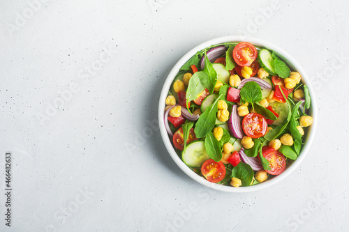 Top view of chickpea salad prepared with tomatoes and cucumber, copy space