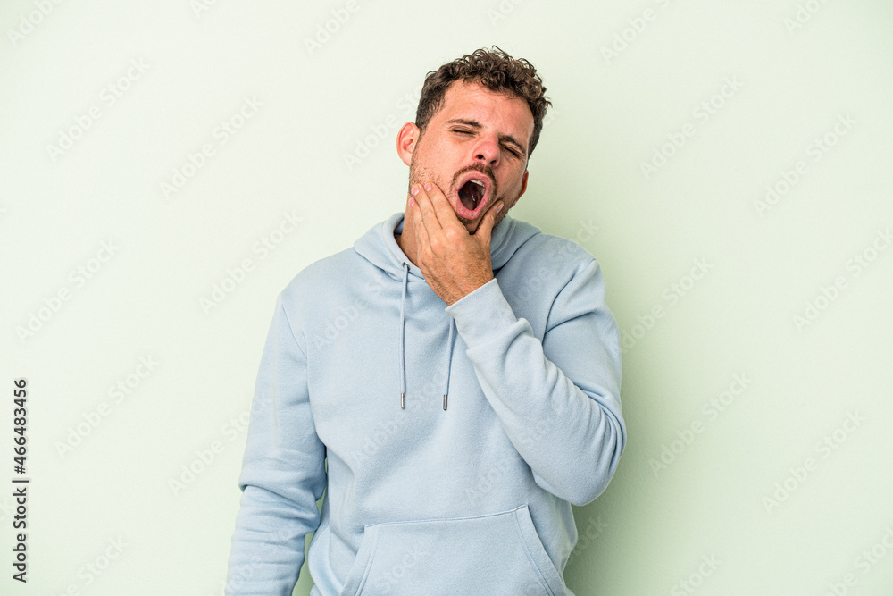 Young caucasian man isolated on green background having a strong teeth pain, molar ache.