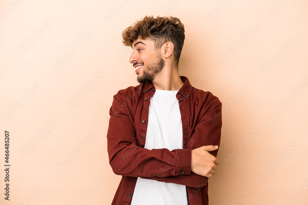 Young arab man isolated on beige background laughing and having fun. Young arab man isolated on beige background laughing and having fun.