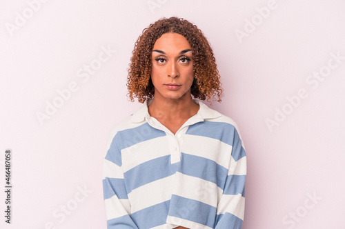 Young latin transsexual woman isolated on pink background sad, serious face, feeling miserable and displeased. photo