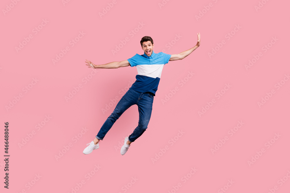 Full size photo of crazy brunet millennial guy jump wear polo jeans sneakers isolated on pink background Full size photo of crazy brunet millennial guy jump wear polo jeans sneakers isolated on pink background