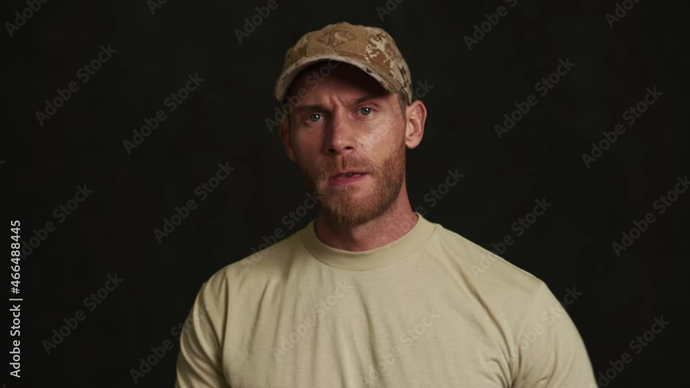 Strong military man take off his jacket in black studio Strong military man take off his jacket in black studio