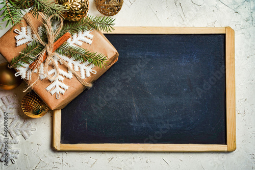 Christmas composition. Christmas gift and pine cones, fir branches on blackbord background. Flat lay, top view, copy space photo